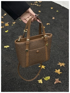 Dettaglio borsa shopper intrecciata marrone vintage con manici in pelle e finiture dorate