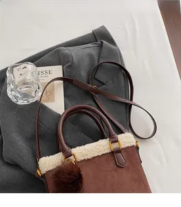 Détail du sac marron en suédine avec bordure en molleton et bandoulière réglable