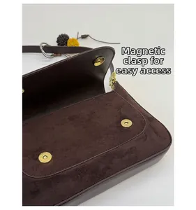 Detailansicht der braunen Wildledertasche mit Doppel-Magnetverschluss und Gold-Hardware