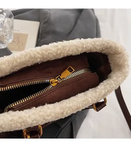 Détail du sac seau en daim marron avec bordure en laine blanche et fermeture éclair dorée