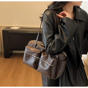 Detail view of dark brown retro leather tote bag with functional silver double zippers
