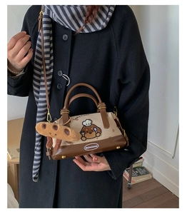 Détail du sac Boston avec broderie chiot et accessoire breloque peluche croissant