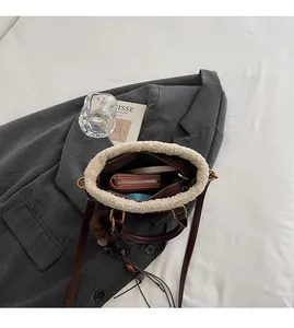 Vue détaillée du compartiment intérieur spacieux du sac seau marron en daim et fausse fourrure