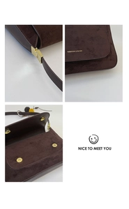 Detaillierte Nahaufnahme der braunen Ledertexturen und Goldschnallen der Handtasche
