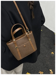 Borsa tote marrone intrecciata con tracolla in pelle indossata da modella in autunno