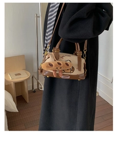 Détail du sac Boston en toile beige avec garniture en cuir et broderie de chiot