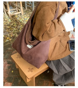 Detail of purple suede tote bag with brown faux shearling lining and UR FAVE label