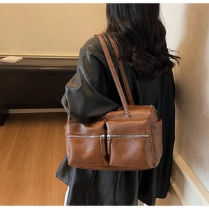 Detail of vintage dark brown faux leather shoulder bag with functional zip pockets