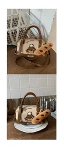 Détail du sac Boston avec broderie Lucky Puppy et charm baguette en peluche sur bois