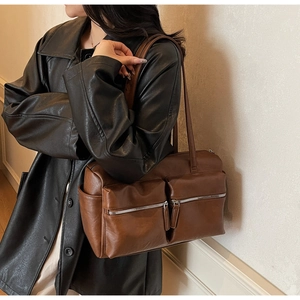 Detail of vintage brown PU leather shoulder bag featuring dual silver front zippers