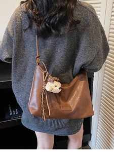 Vintage brown leather tote bag with a cute puppy pendant and slim shoulder straps