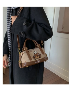 Détail du sac Boston avec écusson chien et toile à pois porté par un mannequin