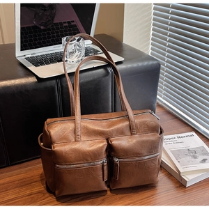 Detailed macro view of vintage brown PU leather shoulder bag with functional dual front zippers