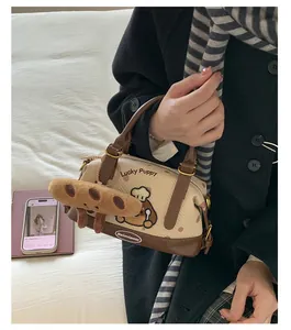 Détail d'un sac Boston en toile avec broderie de chien et breloque en forme d'os