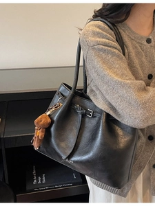 Large vintage pleated black leather tote bag for women with a brown plush bear charm