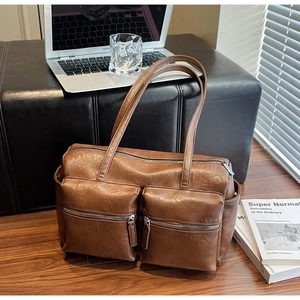 Detail of a brown chic tote bag with dual front zipper pockets on a stylish background