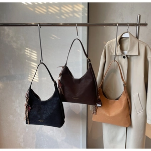 Three minimalist bucket bags in black, dark coffee, and camel with fringe and doll charms
