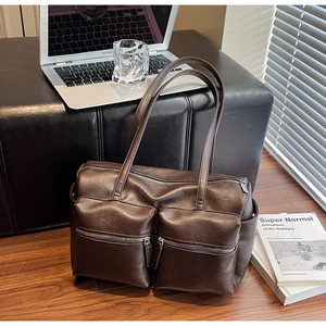 Close-up of deep brown vintage tote bag with dual front zipper pockets and PU leather texture