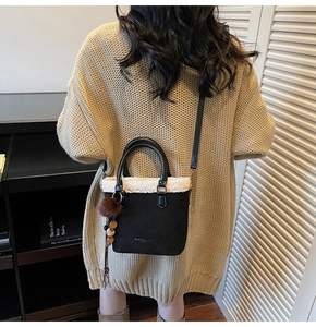 Détail du sac seau en daim vintage avec bordure en peau lainée et pompon en peluche