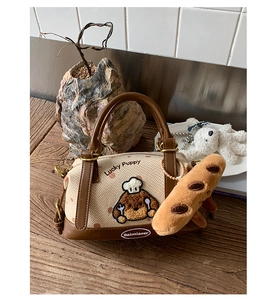 Détail du sac Boston avec broderie de chien de dessin animé et charmant pendentif baguette