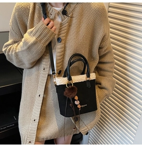 Détail du sac seau vintage en daim noir avec fourrure blanche et breloque perlée