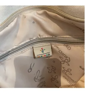 Detail view of the interior lining with Sijichao logo pattern and internal zipper pocket