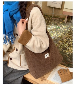 Detailed close-up of brown sherpa tote bag with soft fleece texture and side logo tag