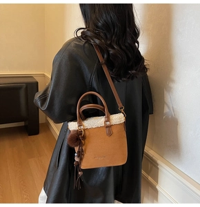 Détail du sac seau en daim marron avec garniture en peluche blanche et bandoulière