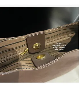 Detail of high-capacity bucket bag showing strong magnetic closure and striped fabric lining
