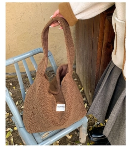 Close-up of brown fuzzy fleece tote bag featuring OUR FAVE label on a blue chair