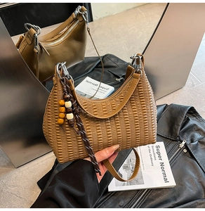 Close-up of caramel woven hobo bag with colorful beads, tassels and silver hardware