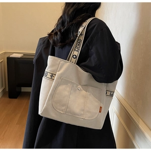 Detail of canvas tote bag with floral SJCHAO printed straps and side orange label