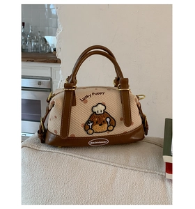 Détails des coutures en toile et de la broderie Lucky Puppy sur ce sac à main Boston chic