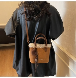 Détail du sac seau vintage marron avec bordure en peau lainée blanche et pompon déco