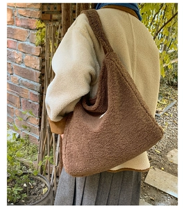 Brown fluffy faux fur tote bag for women showing the shoulder strap detail in outdoor setting