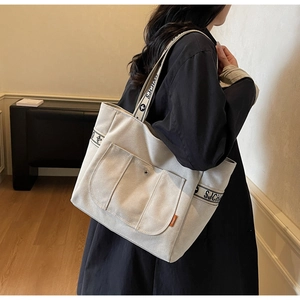 Detail of minimalist cream canvas tote bag with stylish SJCHAO letter printed straps