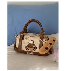 Détail du sac Boston avec broderie chiot et pendentif baguette en peluche douce