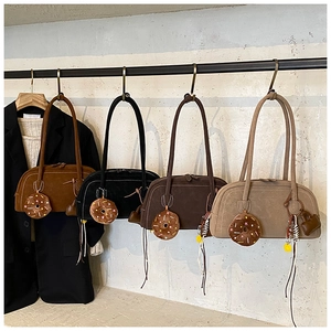 Row of four vintage matte Boston bags with cute donut charms on a metal display rack