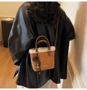 Détail du sac seau en daim avec bordure en fausse fourrure blanche et gland