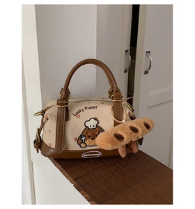 Détail du sac Boston avec broderie Lucky Puppy et breloque peluche baguette sur toile