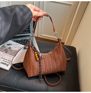 Detail of brown pleated shoulder bag with wooden bead tassel and silver hardware