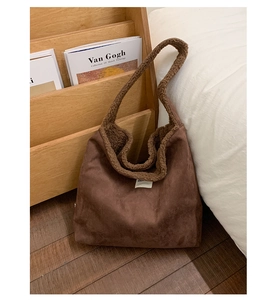 Detail of coffee faux suede tote bag with brown faux shearling trim and white label
