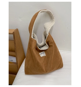 Close-up of brown suede tote bag with white fleece lining and minimalist textile label