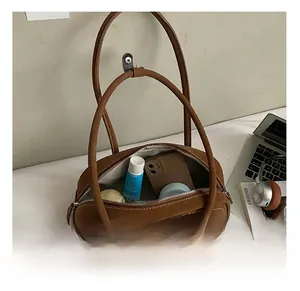 Detailed interior of a vintage brown suede baguette bag showing spacious storage for cosmetics