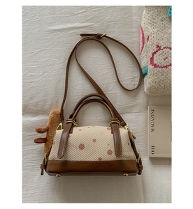 Sac cylindrique beige à pois en tissu et cuir marron avec un petit pendentif en peluche