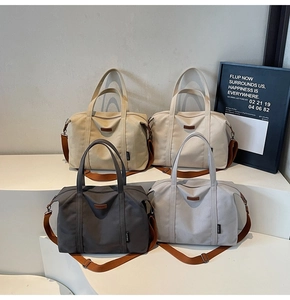 Detail of multi-color canvas tote bags with leather logo and woven handles in four colors