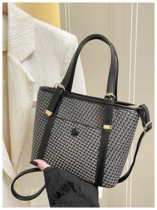Dettaglio della borsa tote in tweed bianco e nero con manici in pelle e finiture dorate