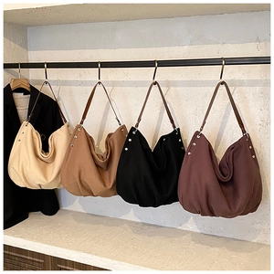 Detailed view of canvas tote bags in beige, brown, black and burgundy with leather straps