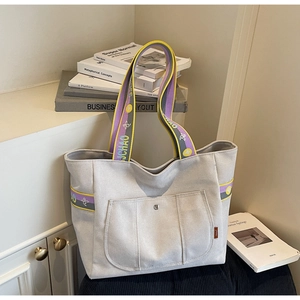 Detail of canvas tote bag featuring colorful jacquard strap with LUCHAO letter embroidery