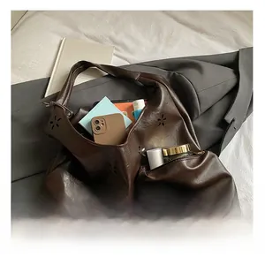 Détail montrant la grande capacité intérieure du sac cabas en cuir marron avec découpes